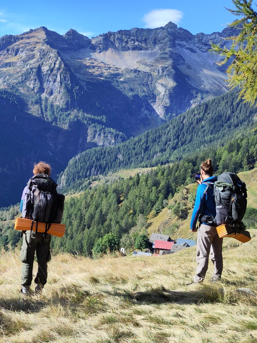 Zwei Männer mit Rucksack blicken in die Berge – ein Bild für Aufbruch, Erinnerung und neue Perspektiven